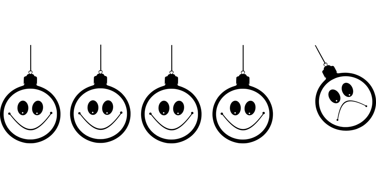 a newton's cradle with smiling faces, the last one has a frown